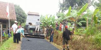 WARGA menonton proses pengaspalan jalan poros desa di Desa Sukamanah, Kecamatan Jiput, Kabupaten Pandeglang, Banten Senin (17/07/2017). Jalan sepanjang 580 meter itu diperbaikai dengan anggaran senilai Rp 249 juta dari Dana Desa 2017.(FOTO: Dendi)
